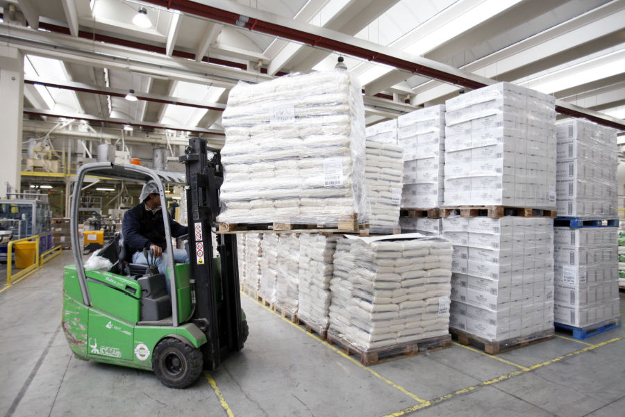 employee using forklift to move pallet load of bagged rice inside the warehouse