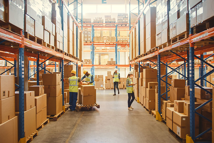warehouse full of shelves with cardboard boxes in pallets