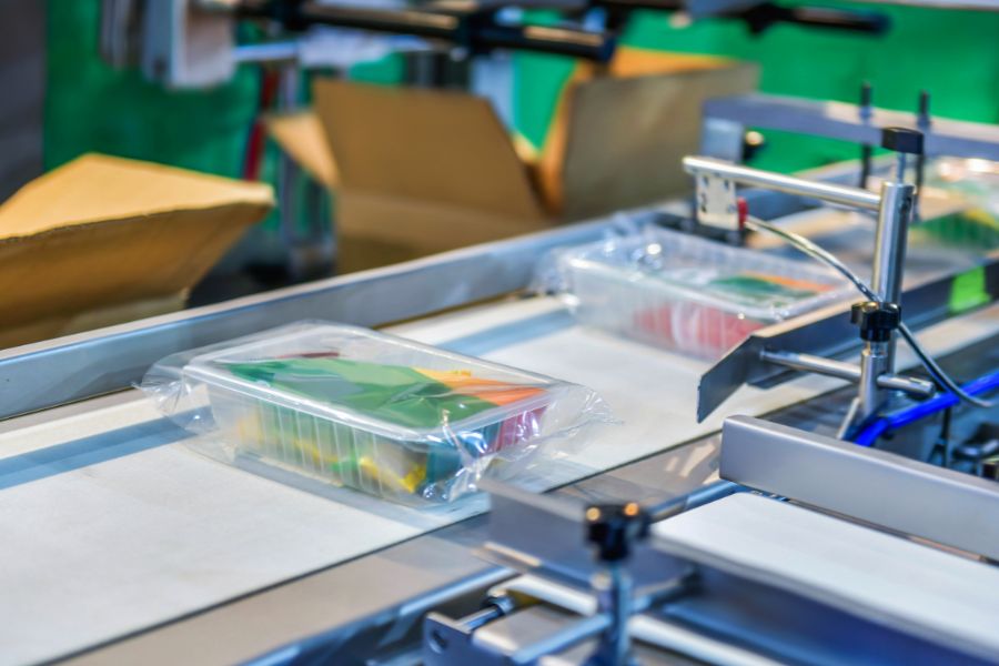 box with food on conveyor belt in food factory