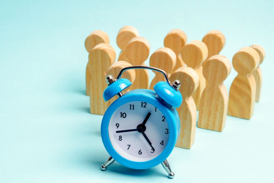 blue clock and bunch of wooden human figure