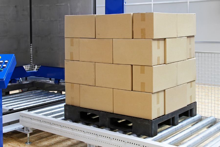 pallet with boxes on conveyor belt of cobot palletizer