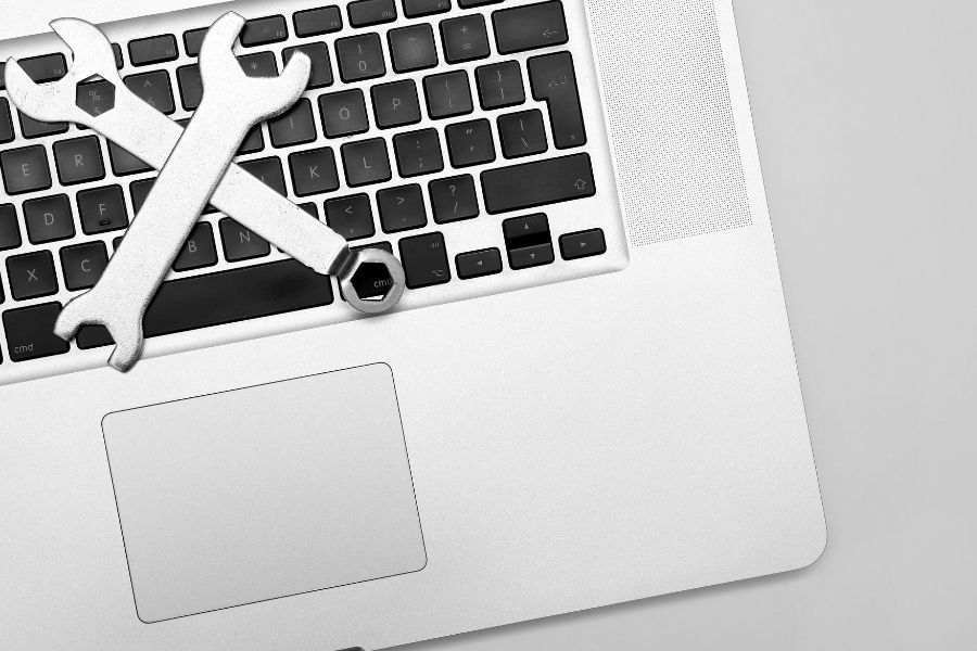 silver laptop with maintenance tool on top
