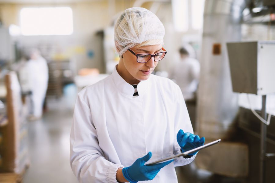 staff at food factory checking guidelines for maintaining food xray machine