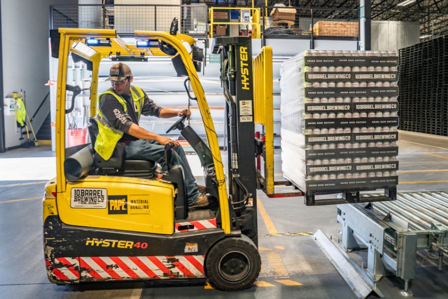 person using forklift with canned products in pallet