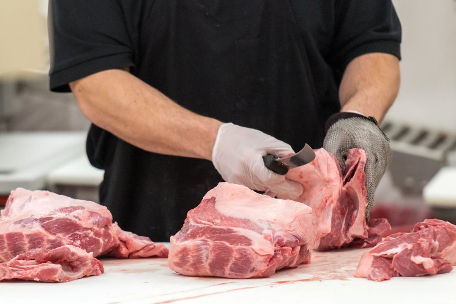 butcher deboning fresh pork meat