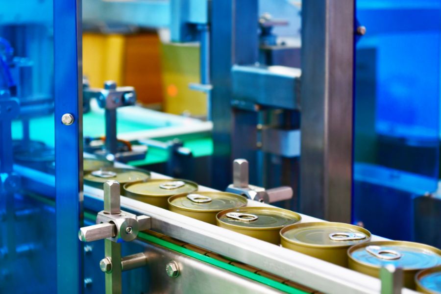 canned food products on conveyor belt at food factory