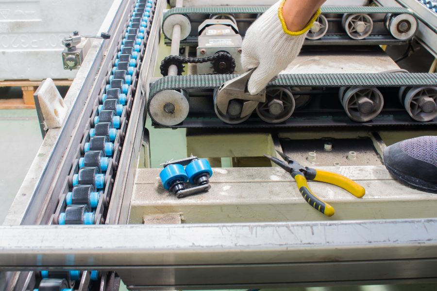 worker maintenance and repairing conveyor belt in food factory
