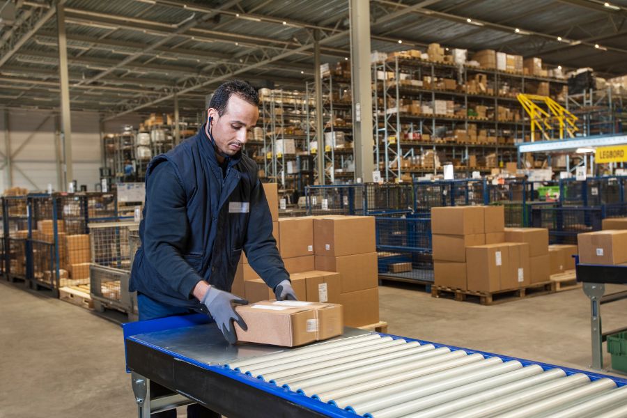 worker sorting packages in distribution center