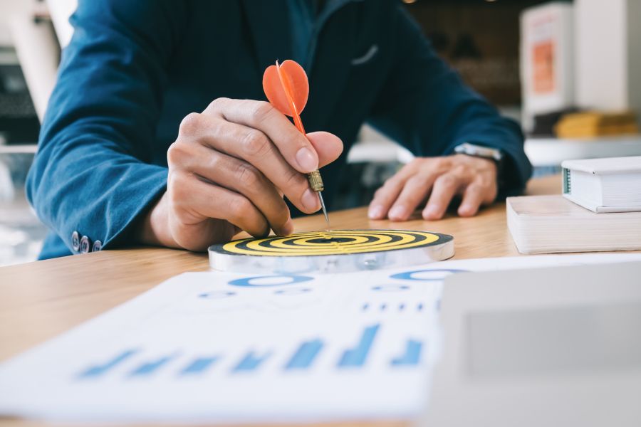 businessman holding darts aiming at the target