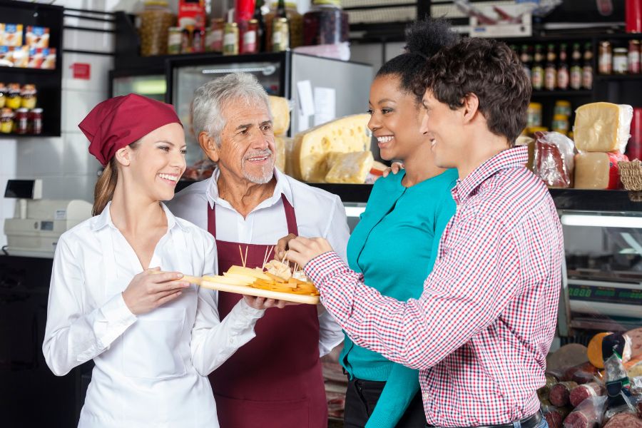 salesperson offering cheese samples to customers