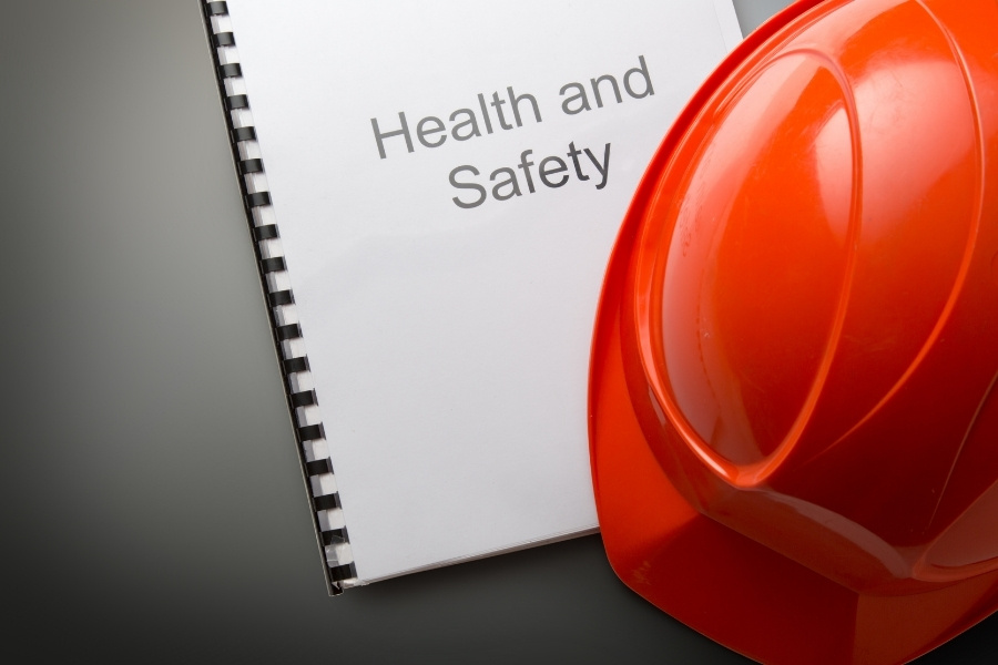 orange helmet on top of health and safety documents